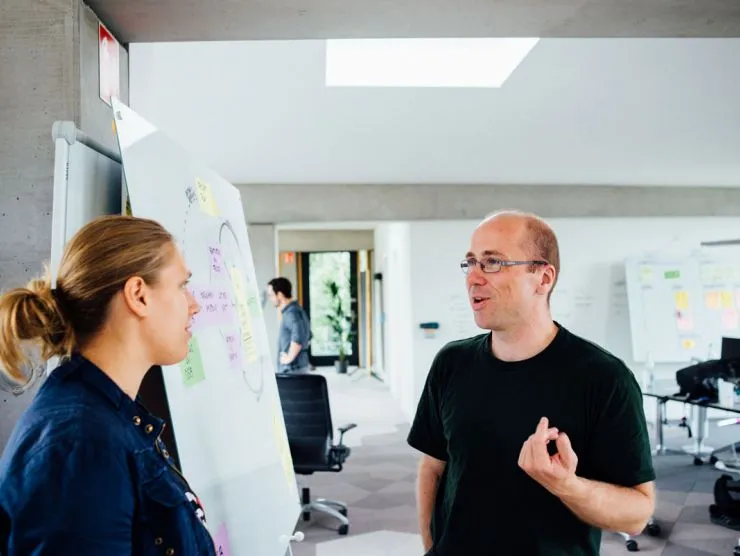 Bild zweier Mitarbeiter an einem Whiteboard